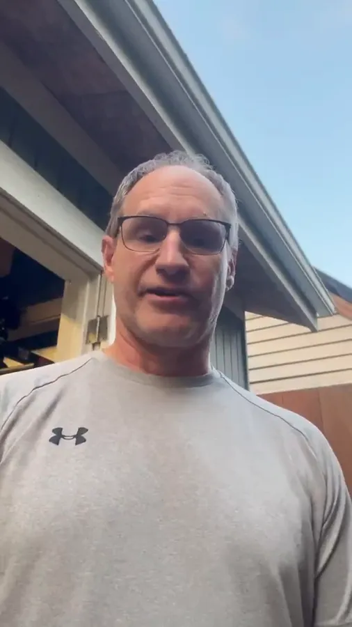 Member in his fifties outside his home